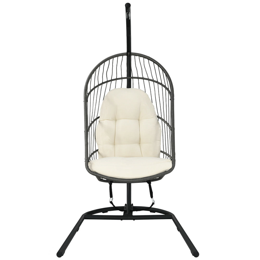 Hanging wicker egg chair with beige cushions, featuring a sturdy steel frame and designed for indoor or outdoor use.