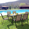 Stackable patio dining chairs with curved armrests and breathable fabric, perfect for outdoor dining by the poolside.