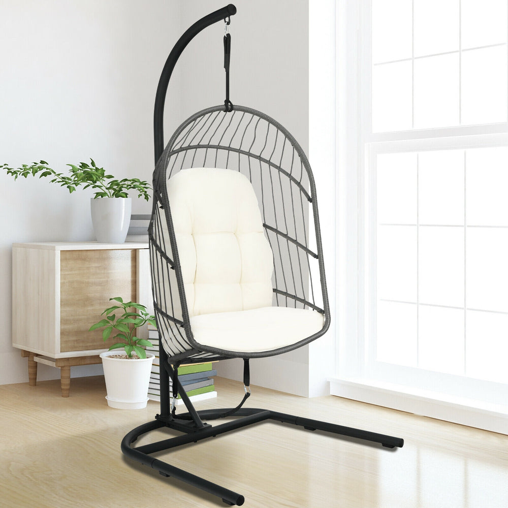 Hanging wicker egg chair with stand in beige, featuring a sturdy steel frame and comfortable cushions for indoor or.