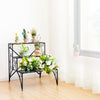 3-tier black metal plant stand with widened grid shelf, showcasing potted plants and flowers for indoor or outdoor use.