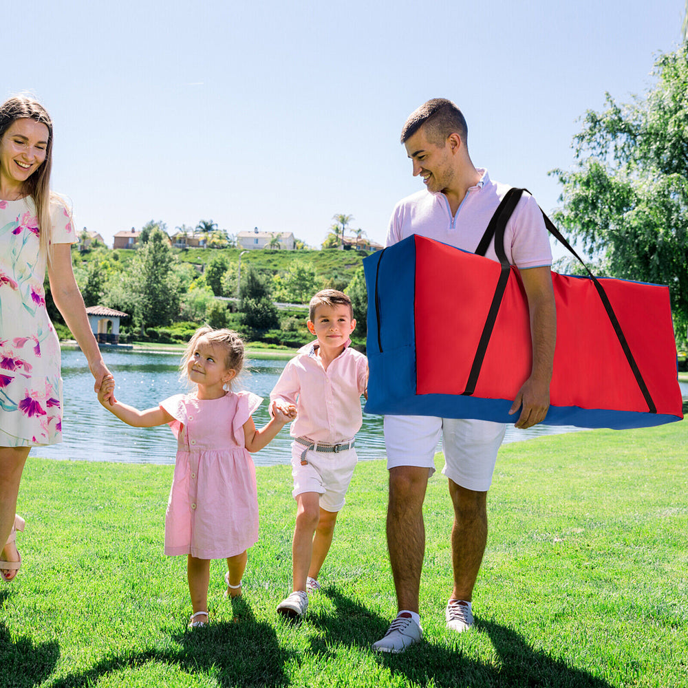 Giant carry storage bag in red and blue, designed for 4 in a Row game, being carried by a family near a lake.
