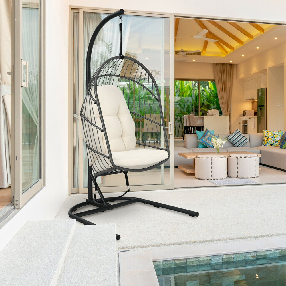 Side view of the hanging wicker egg chair with stand in beige, showcasing its spacious design and comfortable cushions.