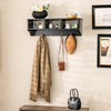Wall-mounted black cubby organizer with hooks, ideal for entryway storage and displaying decor items.