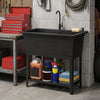 Black 100L utility sink with rotating faucet and storage shelf, ideal for laundry and cleanup in a garage setting.