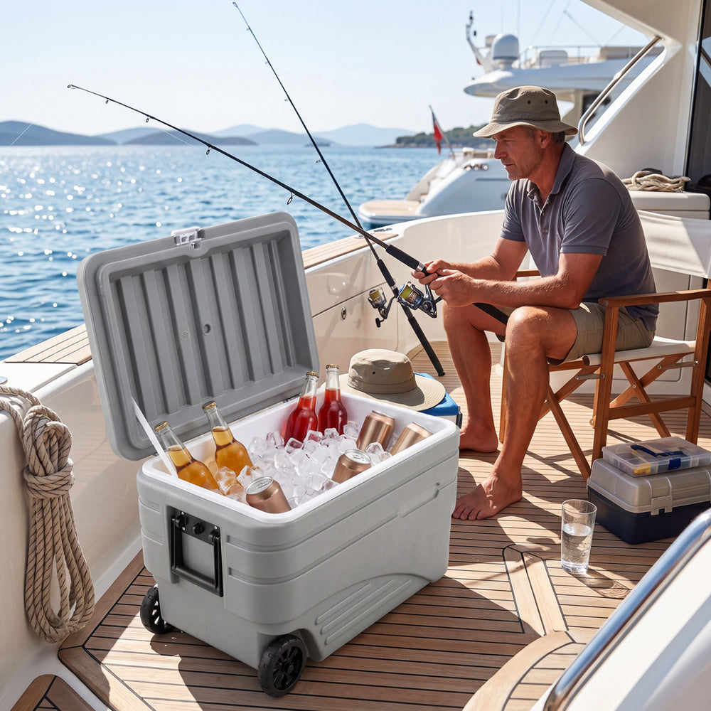 Gray 103 Quart outdoor portable wheeled ice cooler with foldable handles, ideal for keeping drinks cold on a boat.