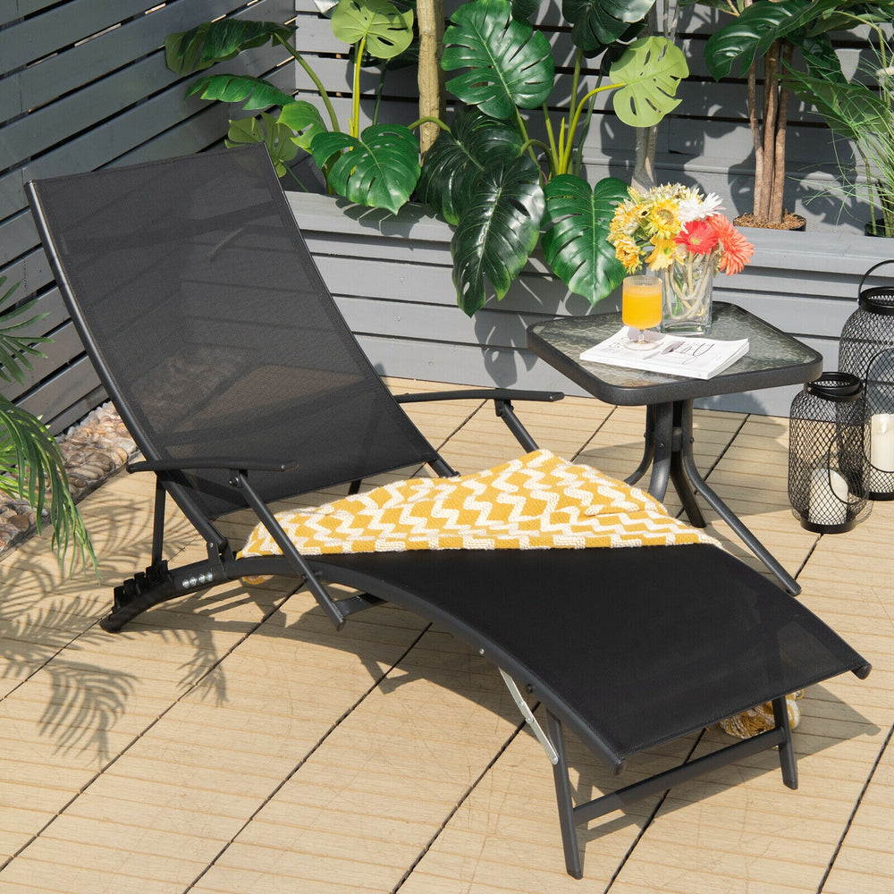 Black patio folding lounge chair with adjustable backrest and ergonomic armrests, perfect for outdoor relaxation.