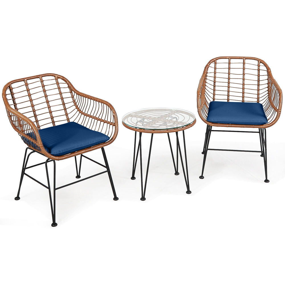 Patio rattan bistro set featuring two armchairs with navy cushions and a glass-top side table, perfect for outdoor.