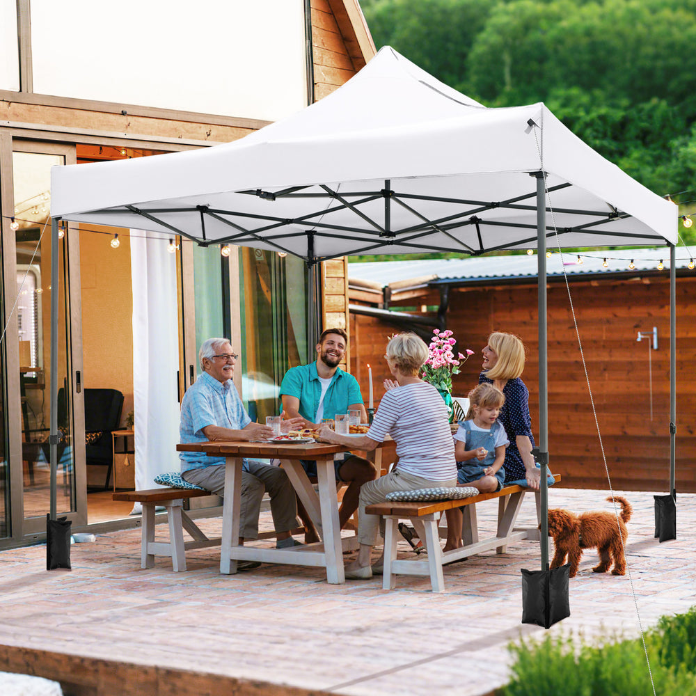Outdoor pop-up canopy tent in white, 10 x 10 FT, providing shade for a family gathering on a patio.