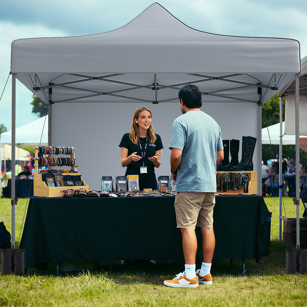 Pop-up canopy tent with gray fabric and removable sidewalls, ideal for outdoor events and markets.