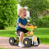 Child riding a green ride-on toy with a steering wheel and train whistle, perfect for outdoor fun and motor skill.