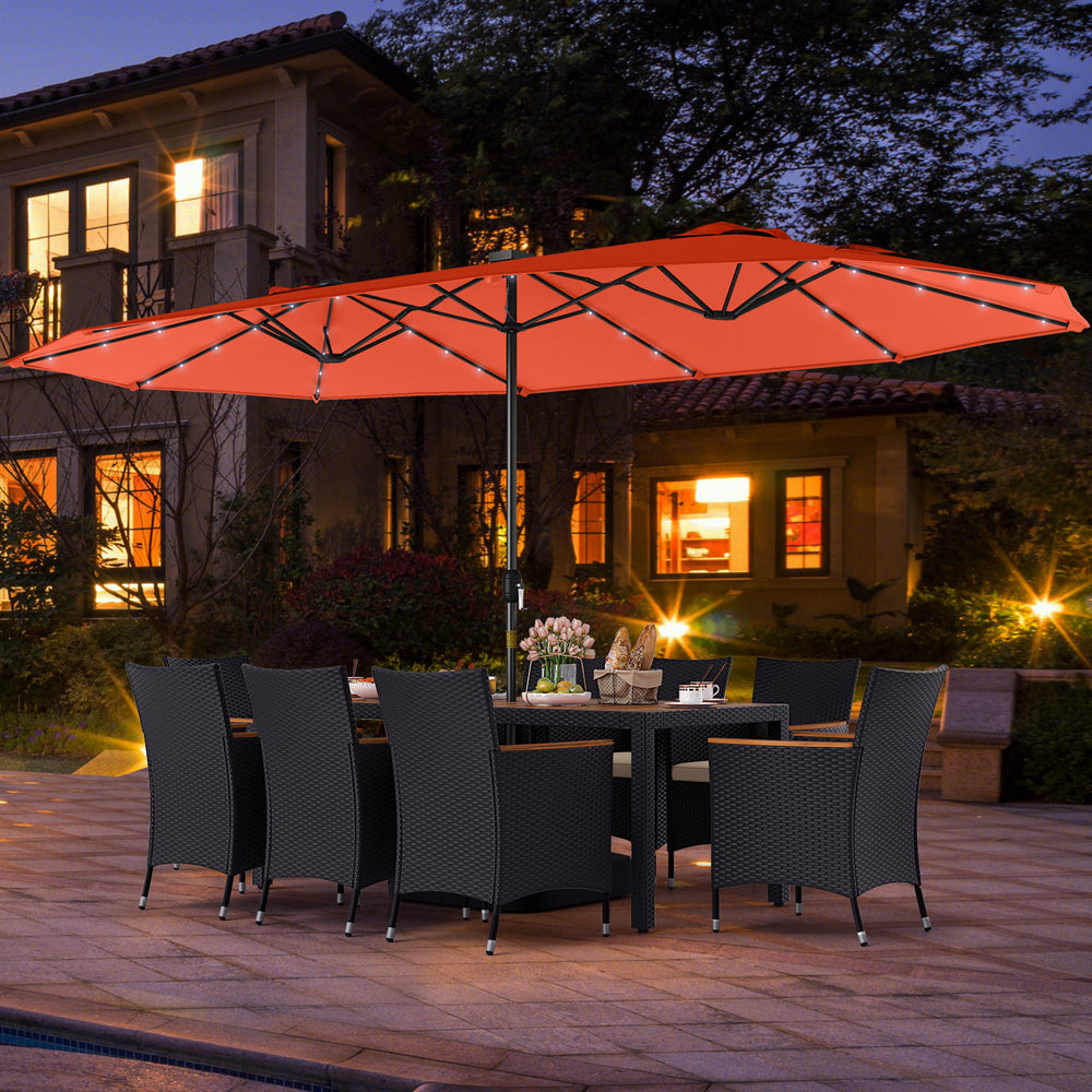 Patio dining set featuring an 11-piece configuration with an orange LED umbrella, cushioned chairs, and acacia wood.