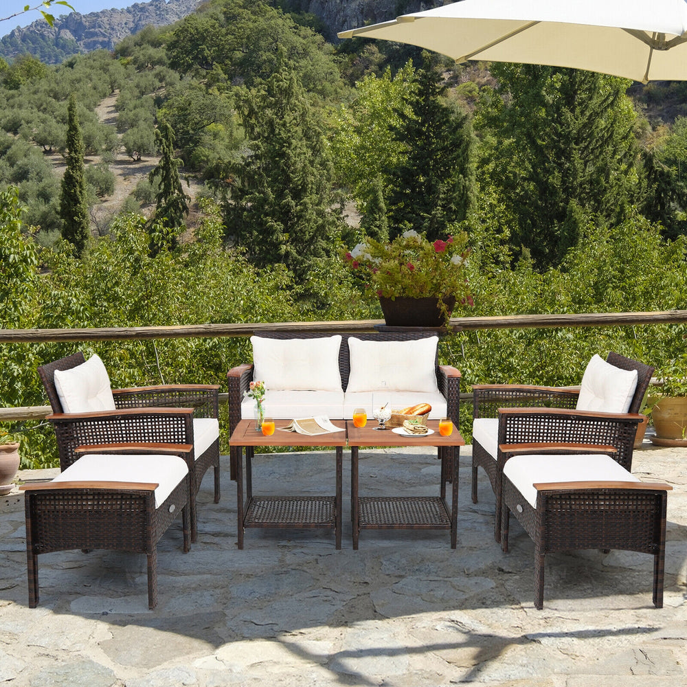 Patio rattan conversation set featuring a loveseat, two chairs, and two ottomans with soft cushions for outdoor comfort.