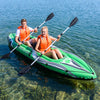 Two people paddling in a green 11.5 feet inflatable kayak with aluminum paddles on clear water.
