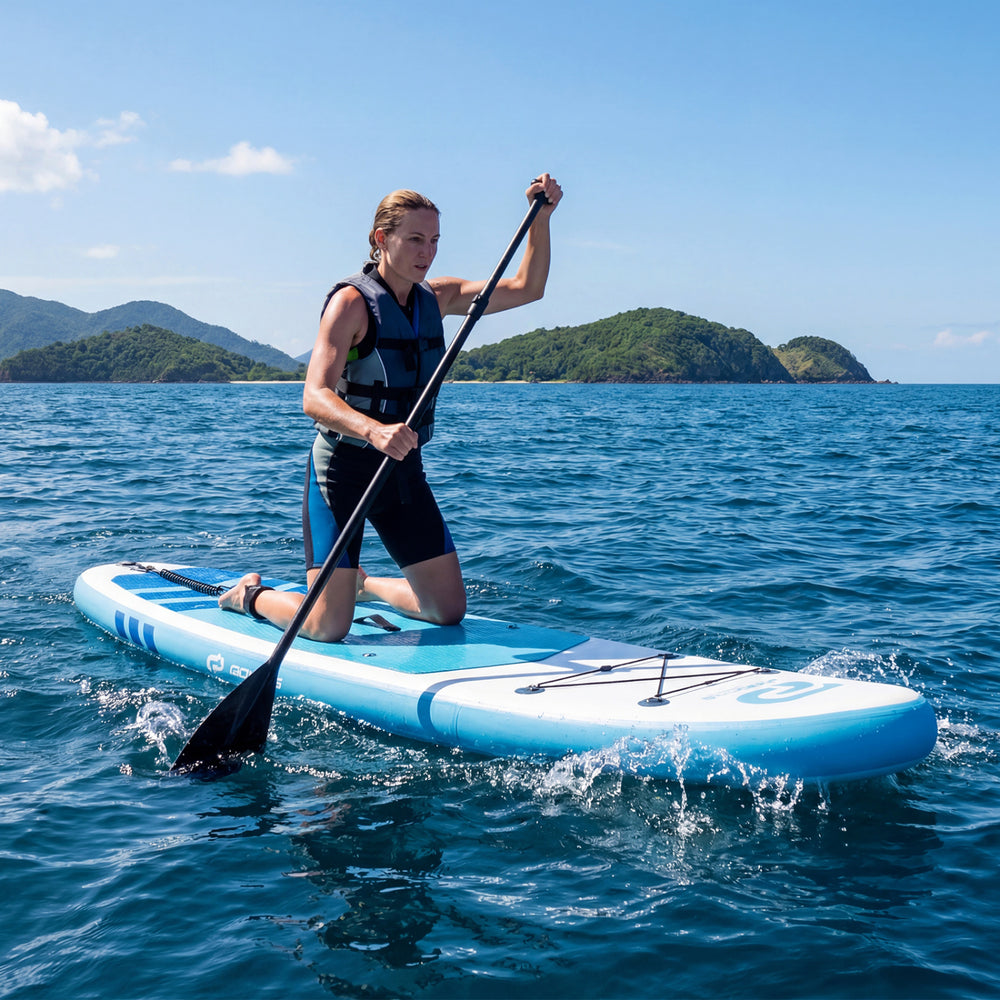 Kneeling paddler on a dark blue 11' inflatable stand-up paddle board, ideal for all skill levels and water adventures.