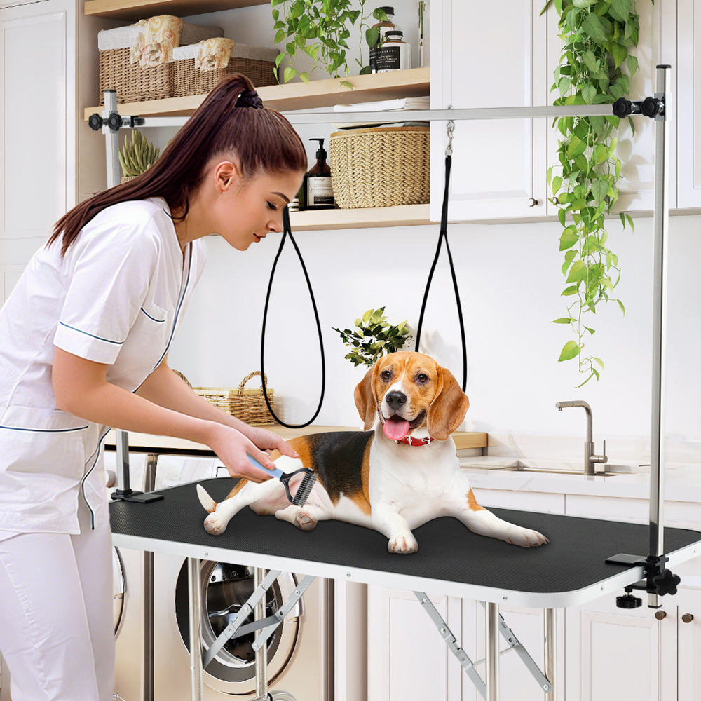 Foldable dog grooming table with height adjustable arms, featuring a non-slip waterproof surface for pet care and.