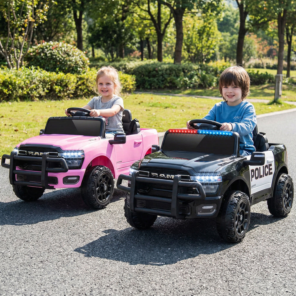 Two kids driving licensed RAM 3500 electric vehicles in black and pink, featuring police lights and remote control.