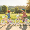 Two girls riding 12-inch pink kids bikes with training wheels and baskets, enjoying a sunny day outdoors.