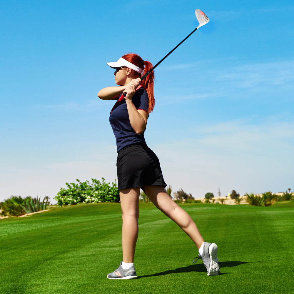 Woman swinging a 12° Individual Driver Golf Club for Women on a golf course, featuring a lightweight aluminum alloy.