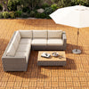 L-shaped outdoor sofa set with beige cushions and a coffee table, perfect for patio relaxation.