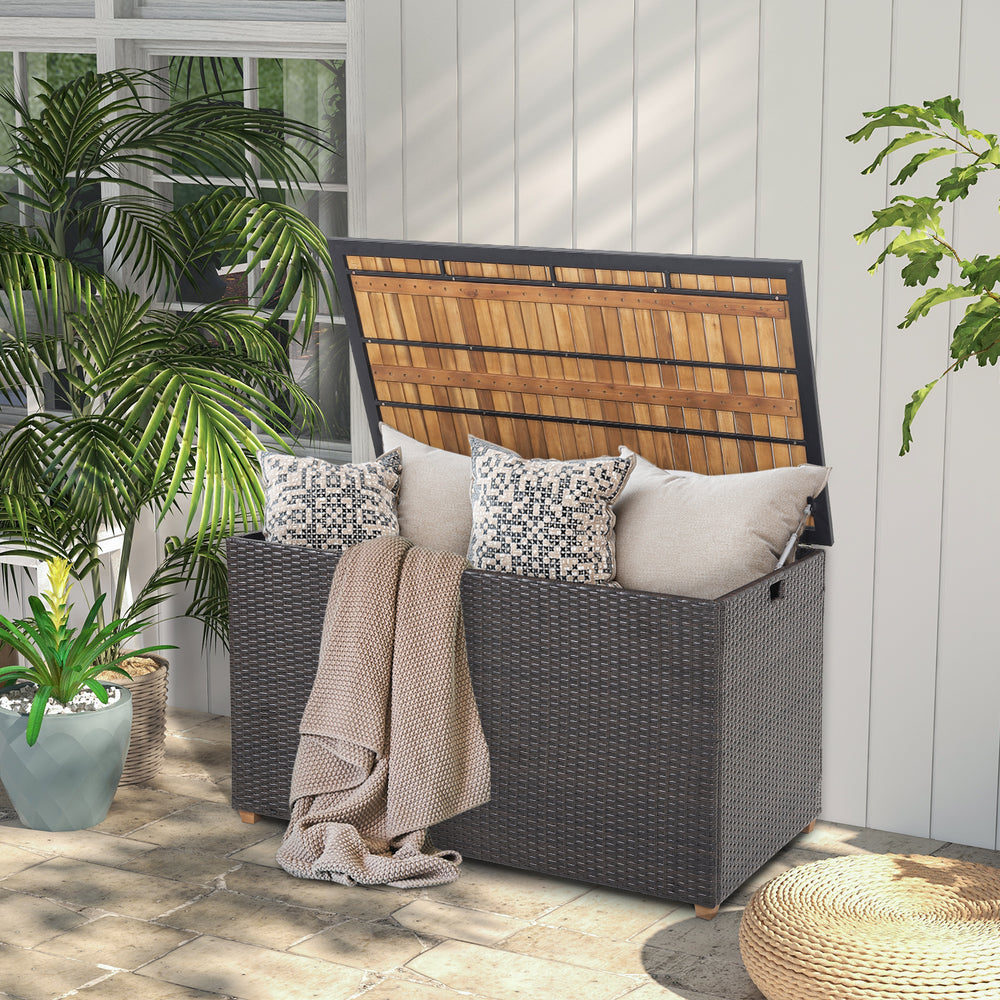Rattan storage box with acacia wood top, featuring a zippered liner, ideal for outdoor patio and backyard use.