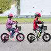 Two kids riding 14-inch adjustable bikes with training wheels, featuring a dual brake system and sturdy metal frames.