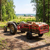 Heavy-duty red metal dump cart trailer with 1540 lbs capacity, loaded with logs, ideal for outdoor hauling tasks.