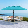 Double-sided 15ft turquoise patio umbrella with metal base, ideal for outdoor shading and stability by the beach.