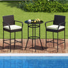 Bar height table and two chairs with white cushions, made of PE wicker, perfect for poolside relaxation.