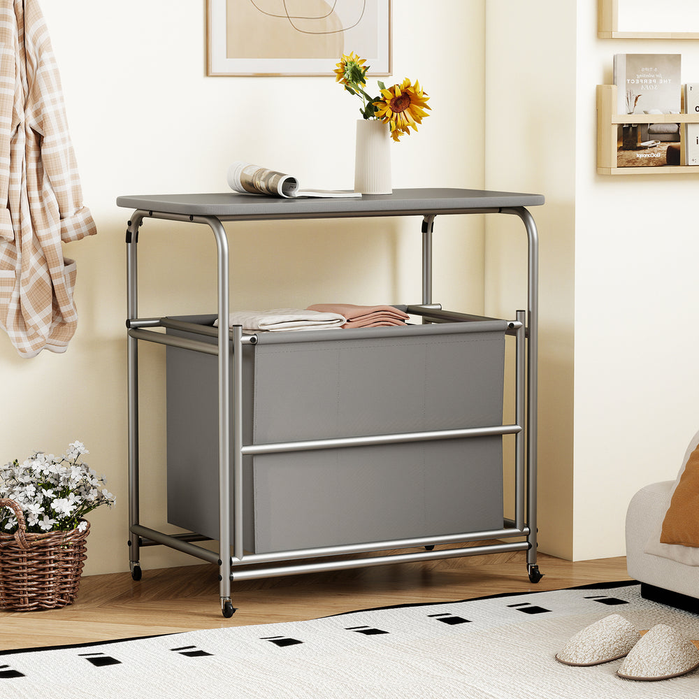 3-section gray laundry sorter with foldable ironing board and lockable wheels, ideal for organizing clothes by color.