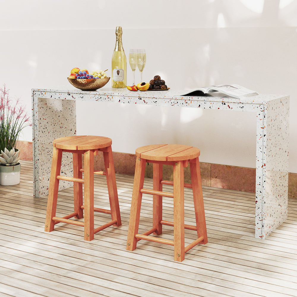 Two 18-inch outdoor wood bar stools with round seats and footrests, perfect for patio or poolside use.
