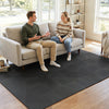 Interlocking black EVA foam floor tiles provide comfort and shock absorption, ideal for living rooms and home gyms.