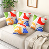 Square throw pillows with colorful designs on a couch, featuring removable velvet cases for easy cleaning.