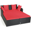 Spacious outdoor rattan daybed with red upholstered cushions, featuring armrests and a curved backrest for comfort.