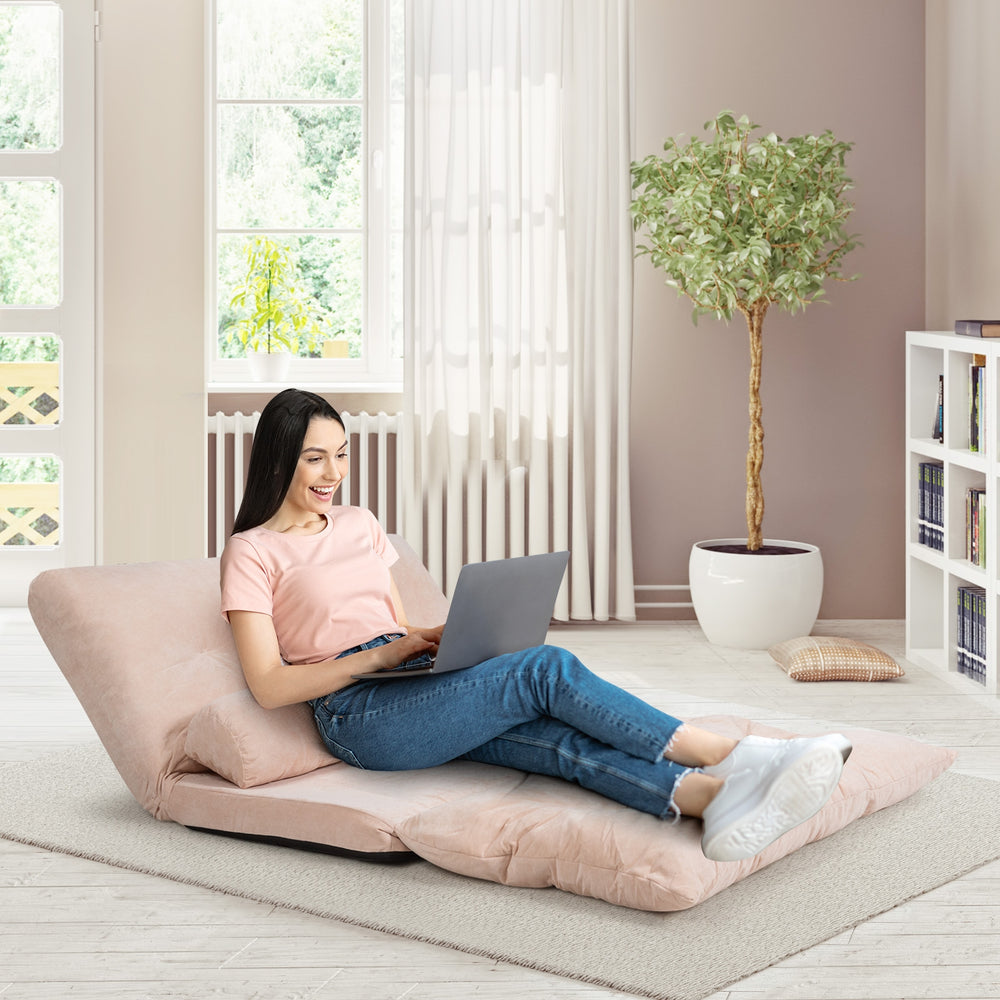 Adjustable beige sleeper lounge couch with two pillows, perfect for relaxing or working comfortably at home.