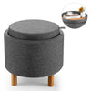 Round gray fabric storage ottoman with removable lid and wooden tray, ideal for extra seating and concealed storage.