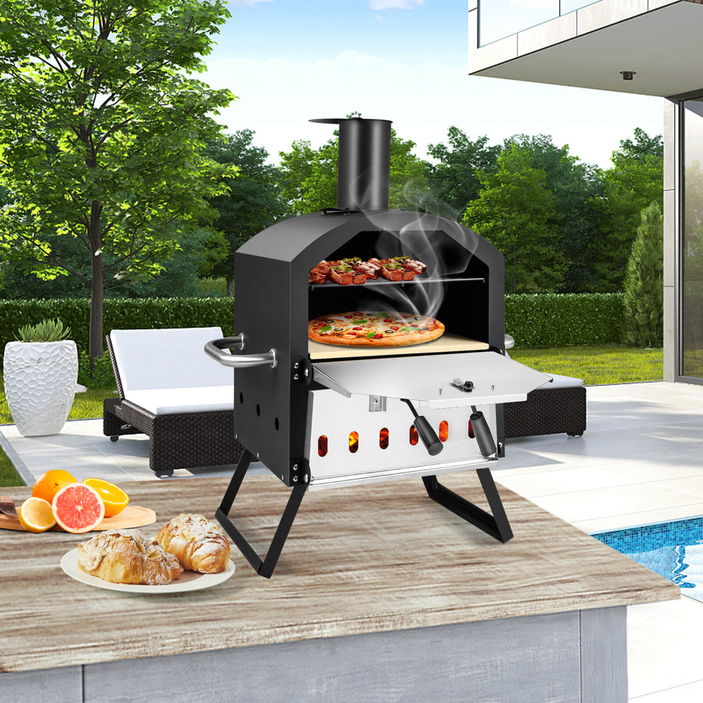 Outdoor pizza oven with foldable legs and anti-scalding handles, designed for cooking two pizzas simultaneously.