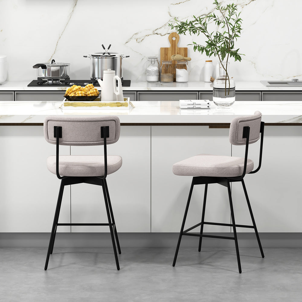 Modern upholstered bar stools with back and footrests in beige, featuring metal legs, ideal for kitchen islands.