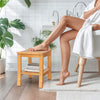 Non-slip shower bench with curved top and storage shelf, made of solid teak, ideal for bathroom use and stability.