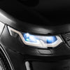 Close-up of the LED headlights on a black 12V kids ride-on car with remote control and realistic design.