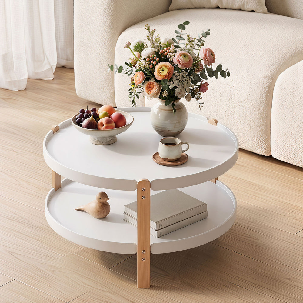 Round 2-tier coffee table with white surface and solid beech legs, featuring open storage for a tidy living area.