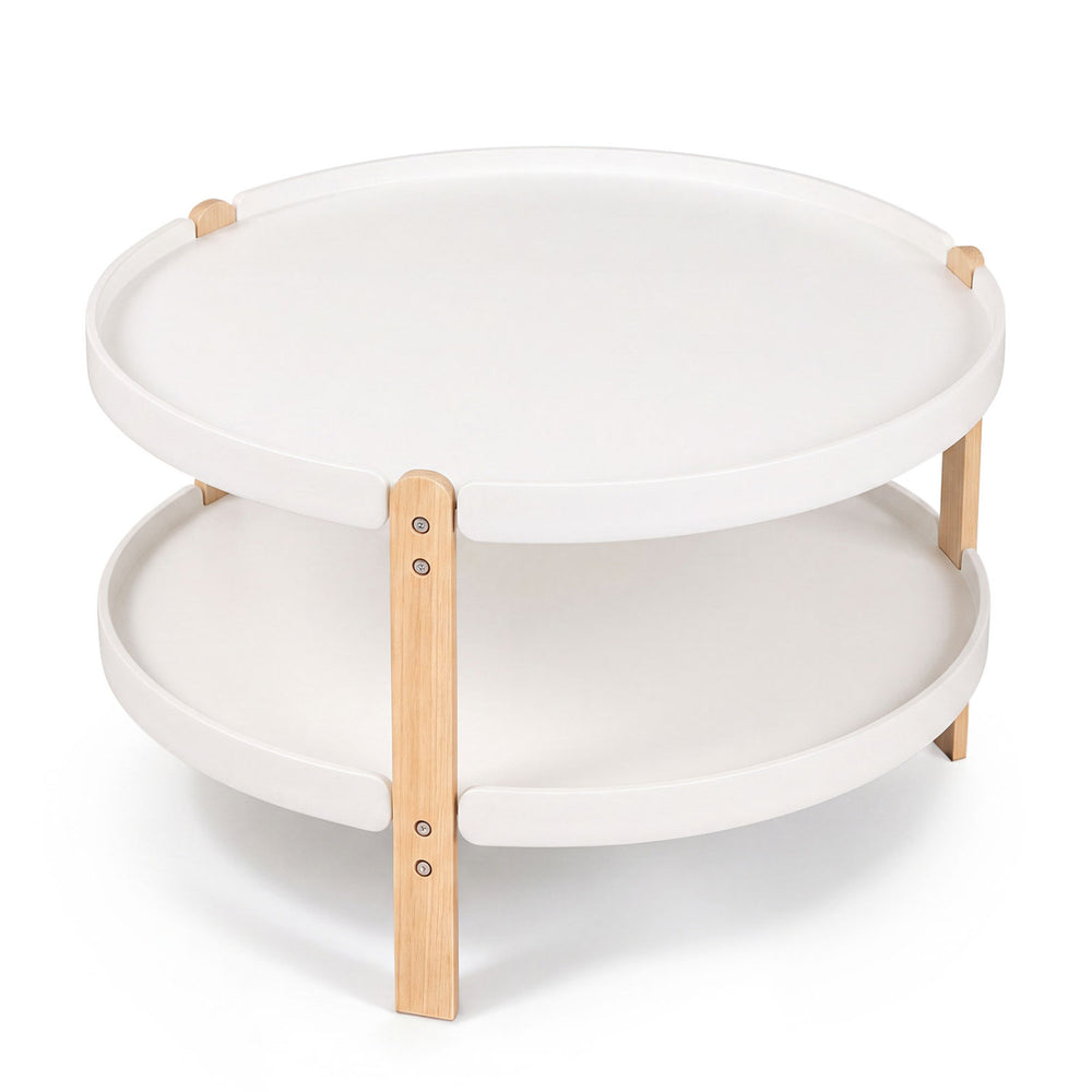 Round 2-tier coffee table with white surface and solid beech legs offers open storage for a tidy living area.