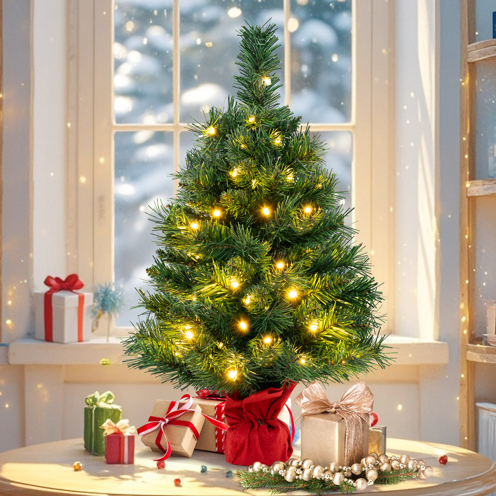 24-inch mini pre-lit Christmas tree with warm white LED lights, red cloth base, perfect for tabletop holiday decoration.