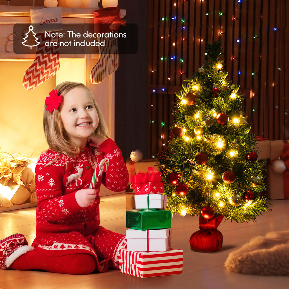 Mini 24-inch pre-lit Christmas tree with warm white LED lights, perfect for tabletop holiday decorations.