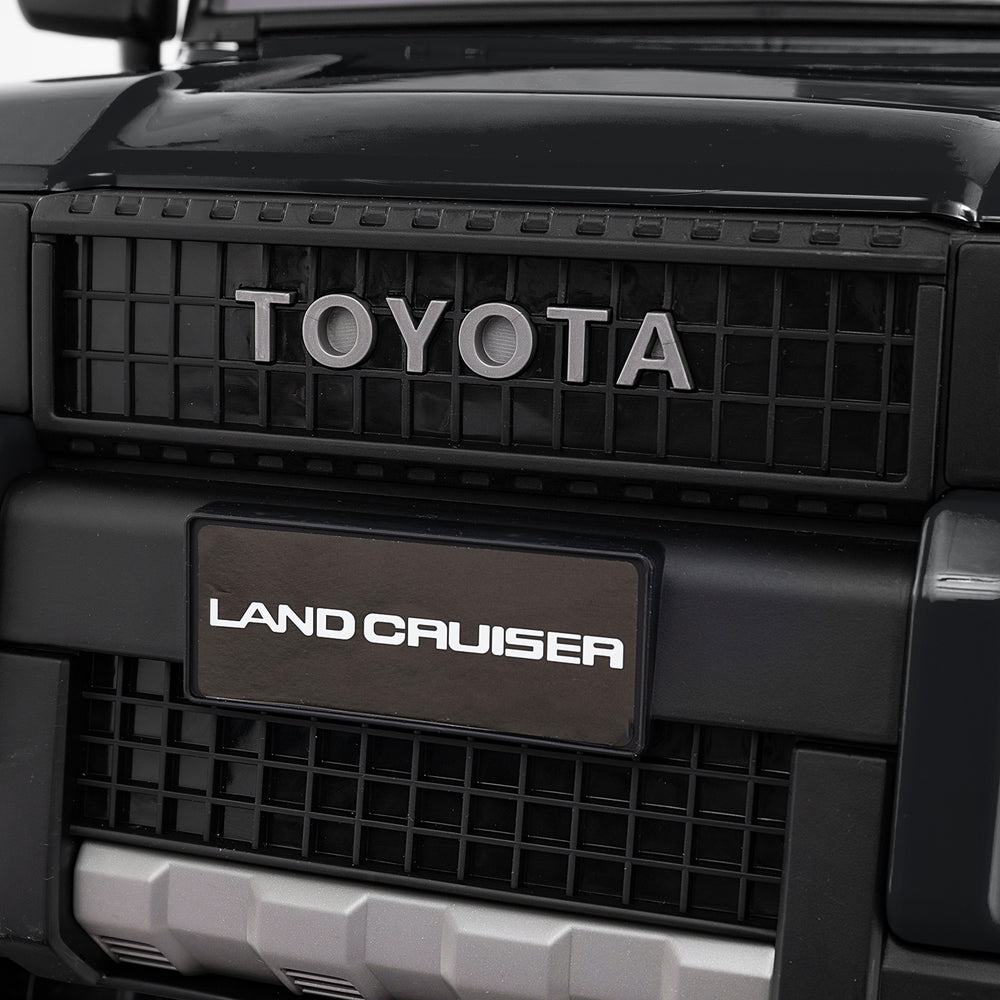 Close-up of the Toyota Land Cruiser front grille on a black 24V kids' ride-on car with remote control features.