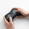 Hands gripping the controller of a 24V kids ride-on dump truck, featuring realistic truck controls for interactive play.