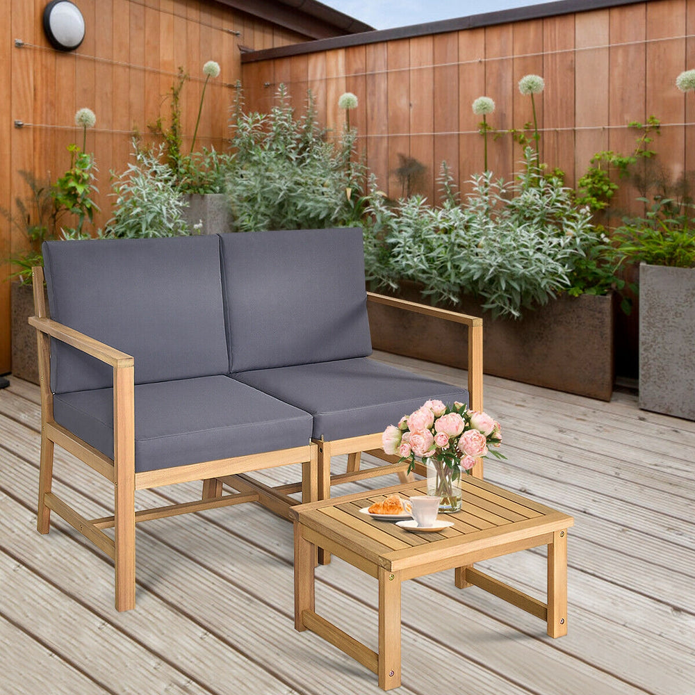 Acacia wood loveseat with grey cushions and separable coffee table, perfect for outdoor patio relaxation.