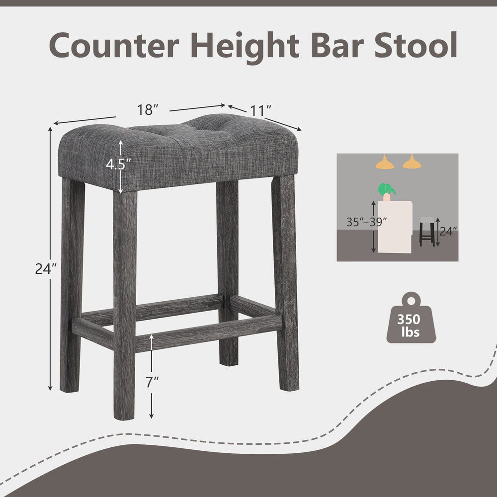 Gray 24-inch counter height bar stool with padded saddle seat, button-tufted design, and solid rubber wood frame.