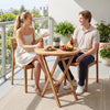 Round 24" solid teak outdoor folding bistro table with footrest, perfect for small spaces on patio or balcony.