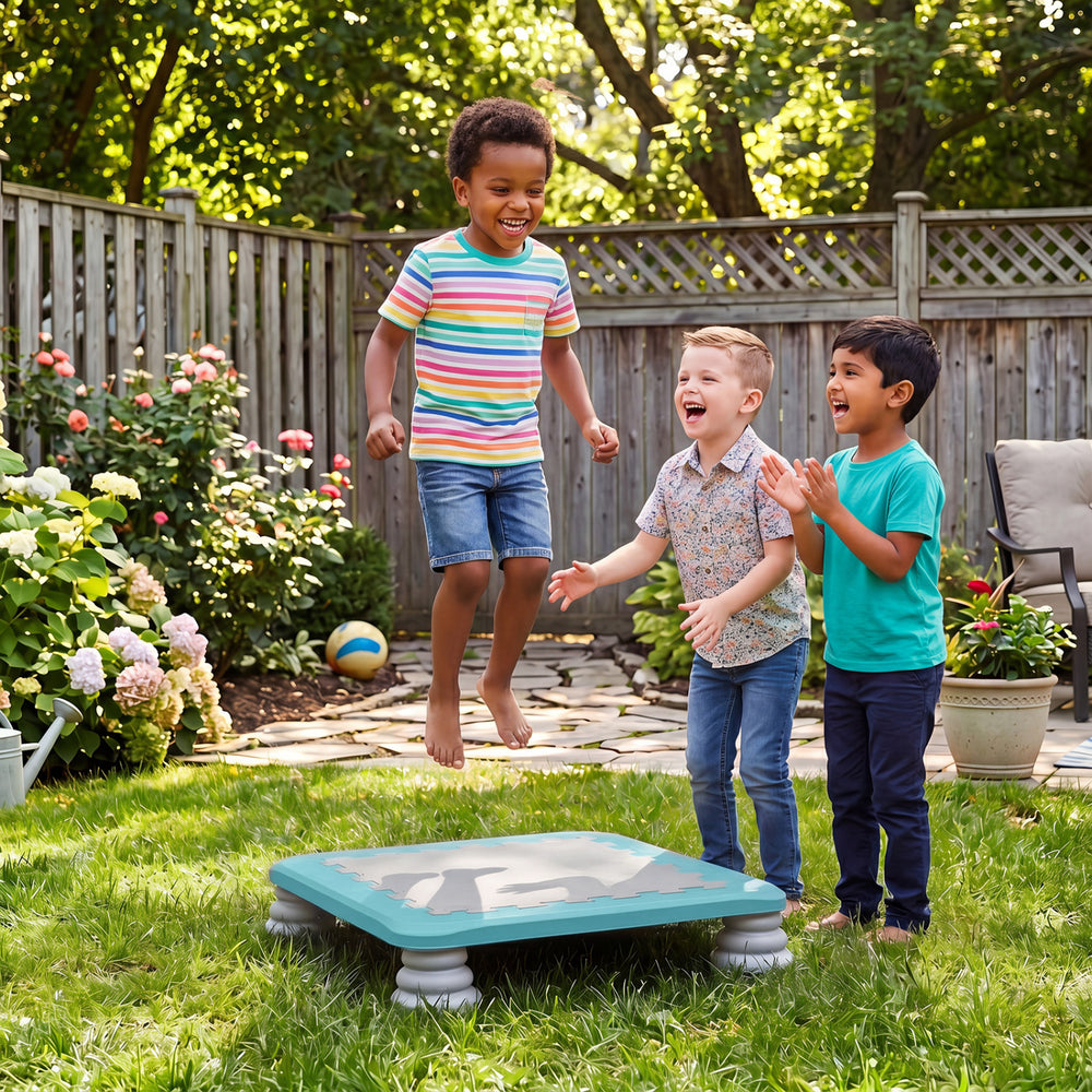 Kids joyfully jumping on a 25.5" mini trampoline with non-slip foot pads, perfect for indoor and outdoor play.