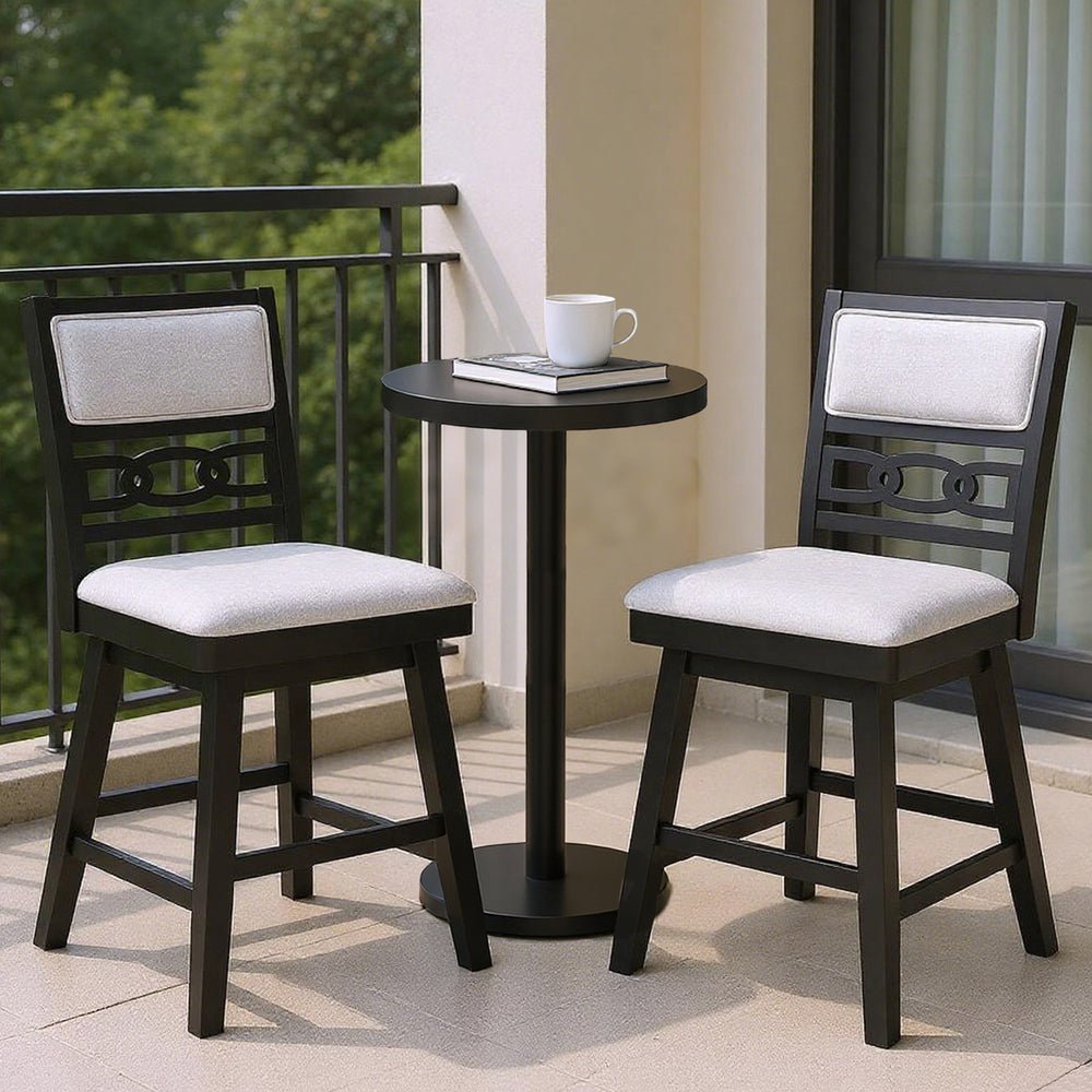 Two black bar stools with upholstered backrests and a small table, perfect for kitchen islands or cafes.
